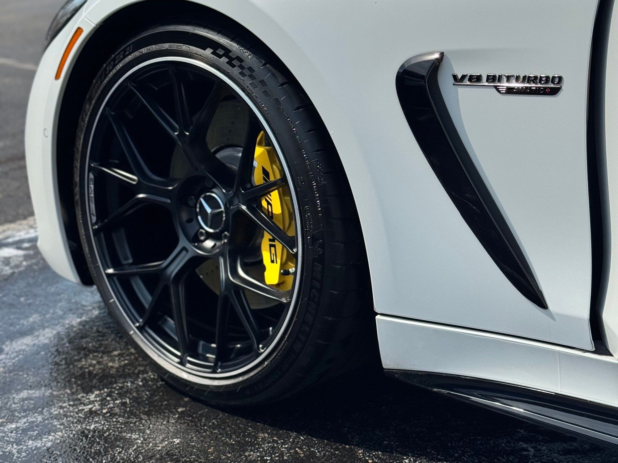 Glossy white Mercedes-AMG with black wheels and yellow brake calipers