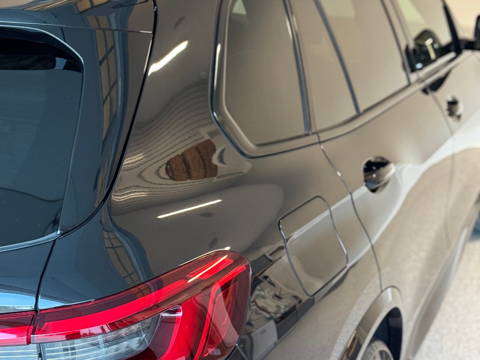 Deep gloss and clear reflections on the black paint of an SUV after polishing